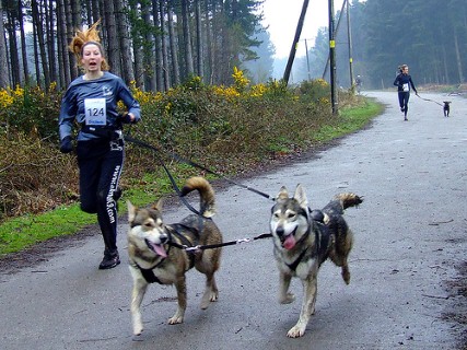 a woman runs with some dogs